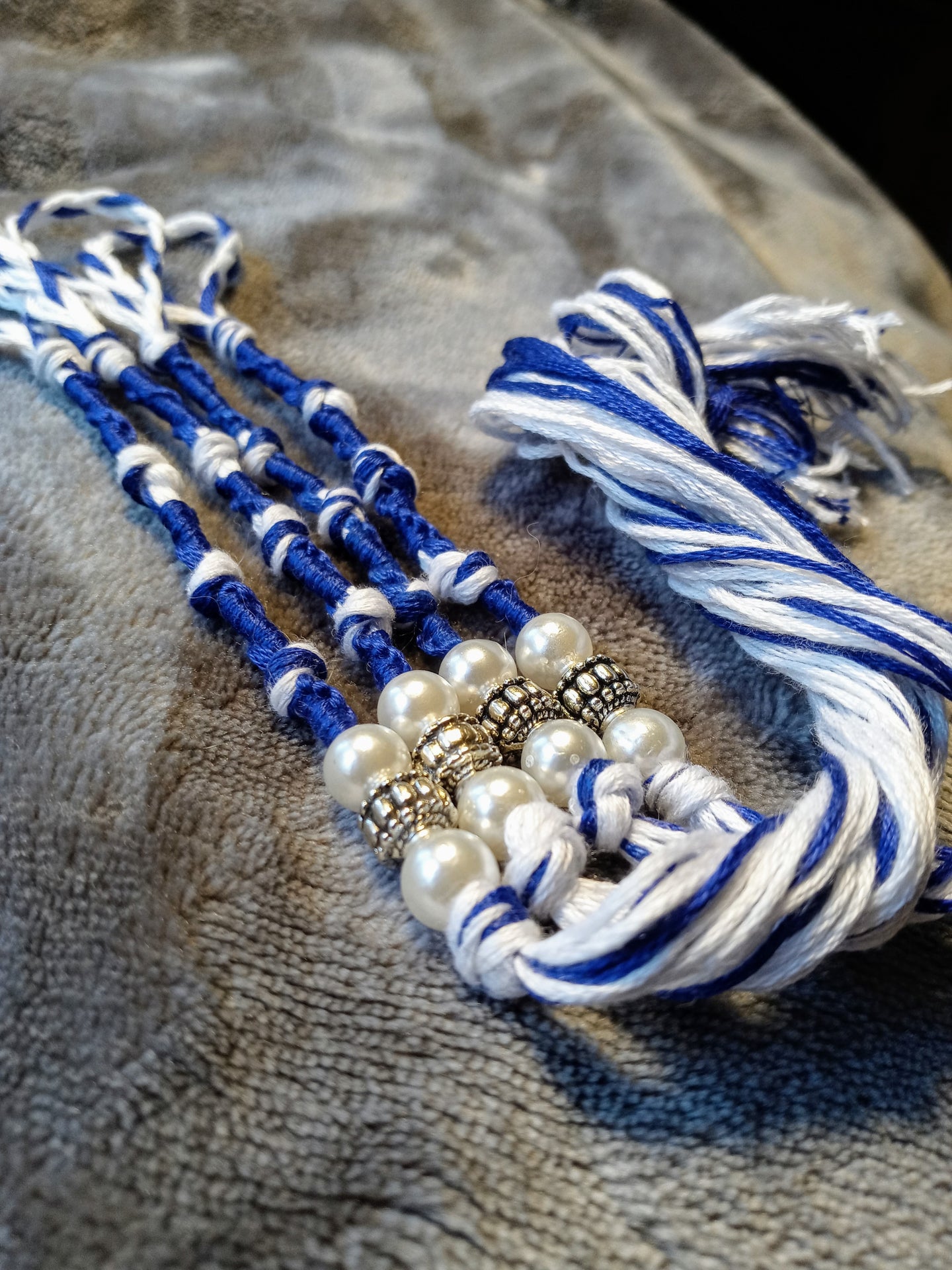 Royal blue and white tzitzyot with white pearls and silver-colored beads